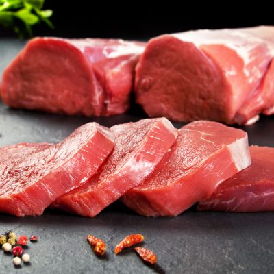 Fresh and raw meat. Sirloin medallions steaks in a row ready to cook. Background black blackboard